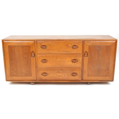 1059 - Late 20th century Ercol elm sideboard fitted with three central drawers flanked by cupboards on cast... 