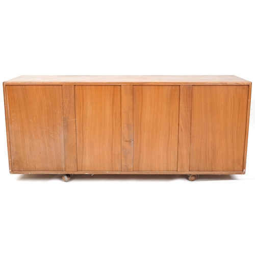 1059 - Late 20th century Ercol elm sideboard fitted with three central drawers flanked by cupboards on cast... 