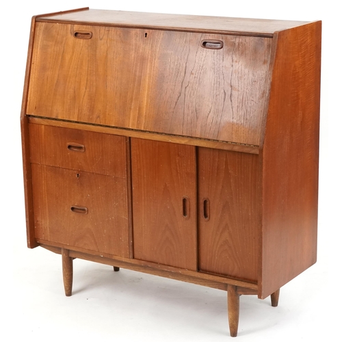 1057 - Mid to late 20th century teak bureau, the fall flap above two drawers and a cupboard on tapering leg... 