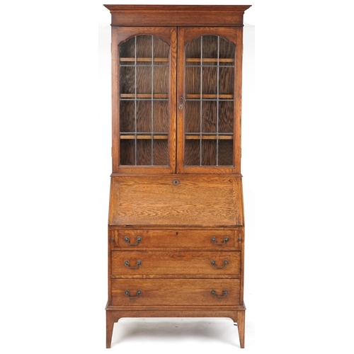 1062 - Edwardian oak bureau bookcase fitted with a pair of leaded glazed doors, the fall front above three ... 