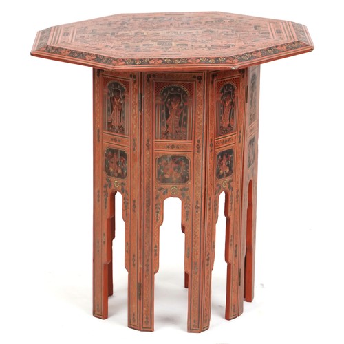 1021 - Late 19th century Burmese red lacquer octagonal folding table, the top profusely decorated with figu... 