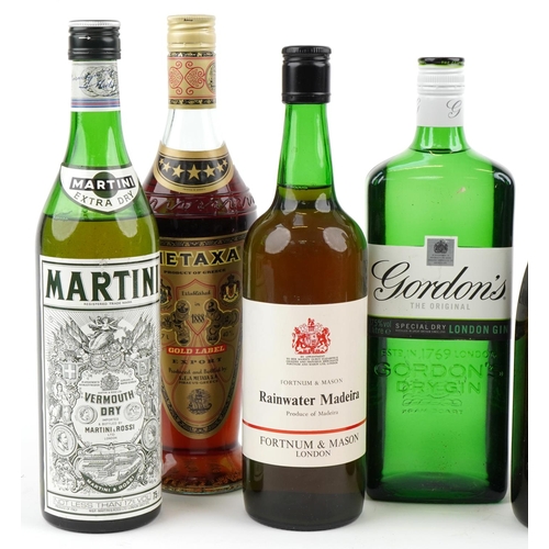 569 - Seven bottles of alcohol including vintage 1975 wine, Gordons gin and Martini.