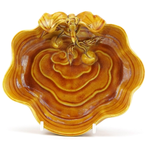 151 - A Chinese porcelain yellow glazed brush washer relief decorated with a bat and fruit, 16cm wide.