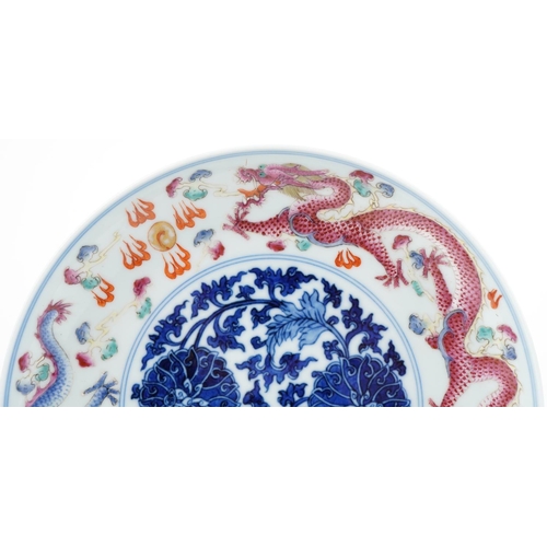 184 - A Chinese porcelain footed plate hand painted with dragons amongst clouds chasing the flaming pearl,... 