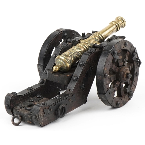 2475 - An early 20th century patinated bronze and wooden model table cannon, 26cm in length.