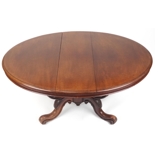 1123 - A late Victorian mahogany centre table, the oval top raised on carved supports and scroll legs, 72cm... 