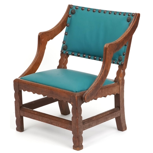 1121 - An early 20th century Gothic Revival oak nursing chair later upholstered in green leatherette, 62cm ... 