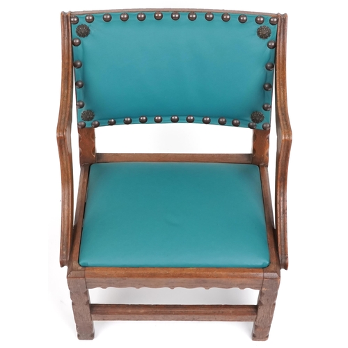 1121 - An early 20th century Gothic Revival oak nursing chair later upholstered in green leatherette, 62cm ... 