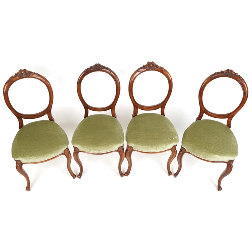 1073 - A set of four Victorian walnut balloon back dining chairs, the overstuffed seats upholstered in gree... 