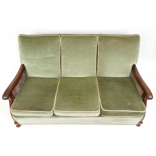 1072 - A George V three piece mahogany framed bergère suite upholstered in green velour comprising three se... 