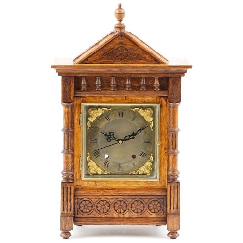 1337 - A carved oak bracket clock having gilt dial with Roman numerals, 51cm high.