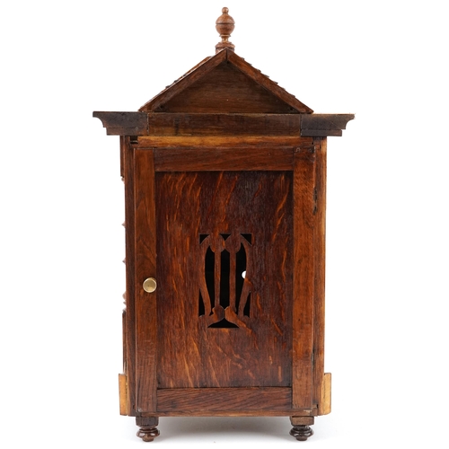 1337 - A carved oak bracket clock having gilt dial with Roman numerals, 51cm high.