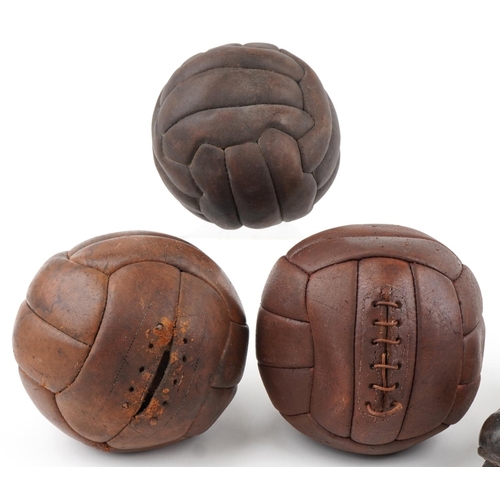  A group of three early 20th century leather footballs, circa 1920, 21cm in diameter, together with a... 