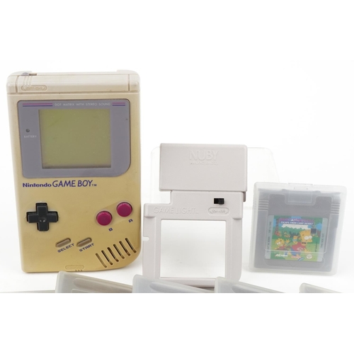 1274 - A vintage Nintendo Gameboy hand held console with a collection of games and booklets including Greml... 