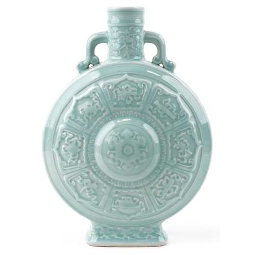 45 - A Chinese porcelain celadon glazed moon flask with twin handles relief decorated with foliage and ob... 