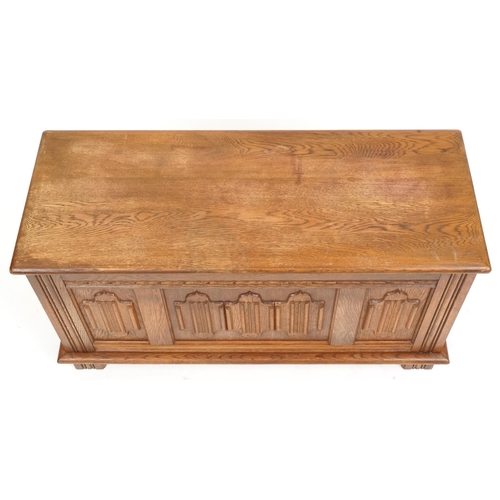 1065 - A late 20th century oak coffer with carved linen fold decoration, 47cm H x 94cm W x 38cm D.