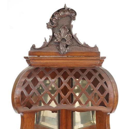 1067 - An early 20th century Rococo Revival mahogany corner display cabinet, the mirrored back above an ast... 