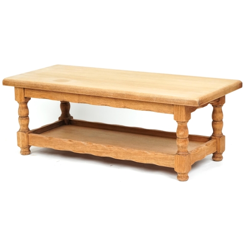 1122A - A late 20th century oak rectangular coffee table raised on turned supports united by an under tier, ... 