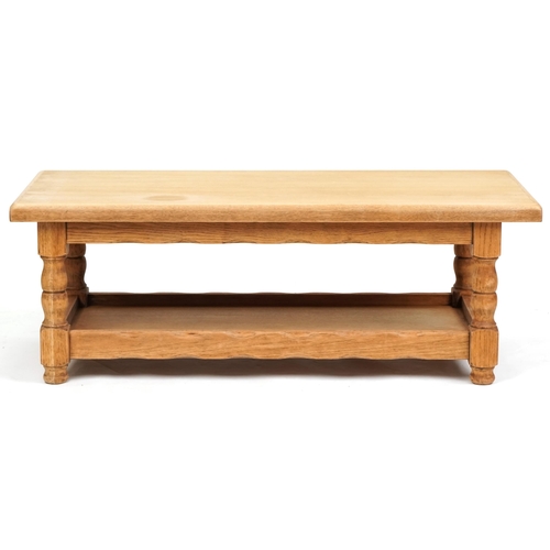 1122A - A late 20th century oak rectangular coffee table raised on turned supports united by an under tier, ... 