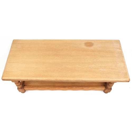 1122A - A late 20th century oak rectangular coffee table raised on turned supports united by an under tier, ... 