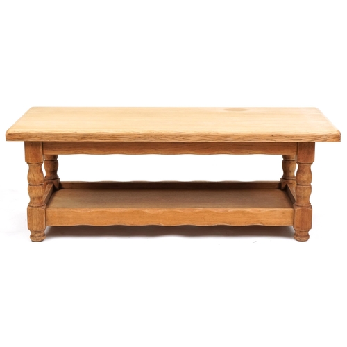 1122A - A late 20th century oak rectangular coffee table raised on turned supports united by an under tier, ... 