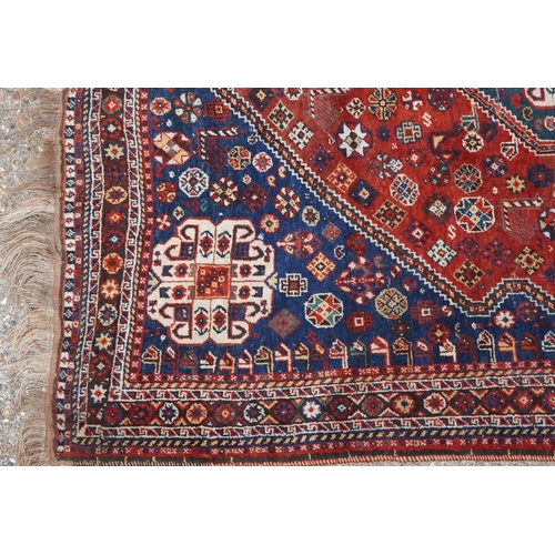 1113 - A Qashqai rug, mid 20th century, the blue field with a central medallion flanked by a border of rose... 