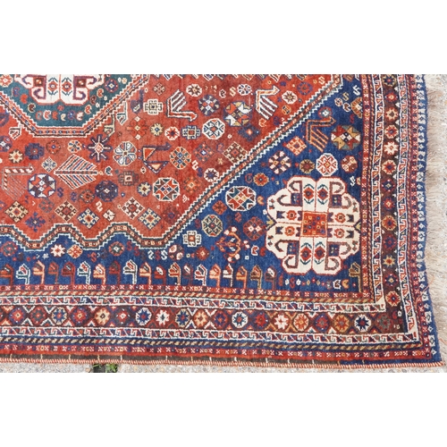 1113 - A Qashqai rug, mid 20th century, the blue field with a central medallion flanked by a border of rose... 