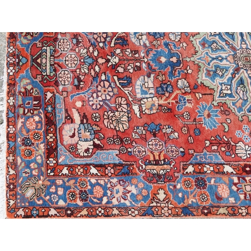 1061 - A Heriz carpet, late 20th century, the red field with a central medallion flanked by complementary b... 