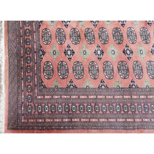 1060 - A Tekke carpet, late 20th century, the salmon field with three rows of guls flanked by a complementa... 