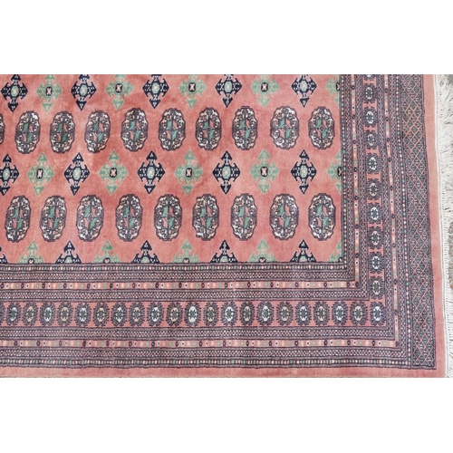 1060 - A Tekke carpet, late 20th century, the salmon field with three rows of guls flanked by a complementa... 