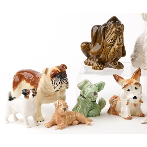 1453 - A large collection of porcelain and pottery dogs, predominantly Sylvac, the largest 22cm high.