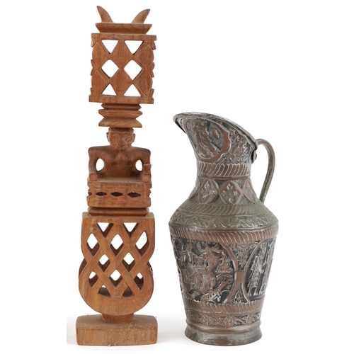 1458 - Three carved wooden statues and a copper jug decorated with animals and figures on horseback, the la... 