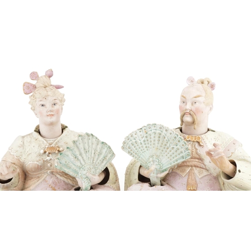 29 - A pair of late 19th century German bisque nodding Chinese figures, each holding a fan and in a kneel... 