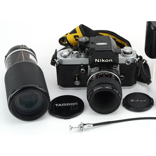 513 - Two Nikon cameras with a collection of lenses including 100mm 2.8, 20mm F-35 and 80-200mm.