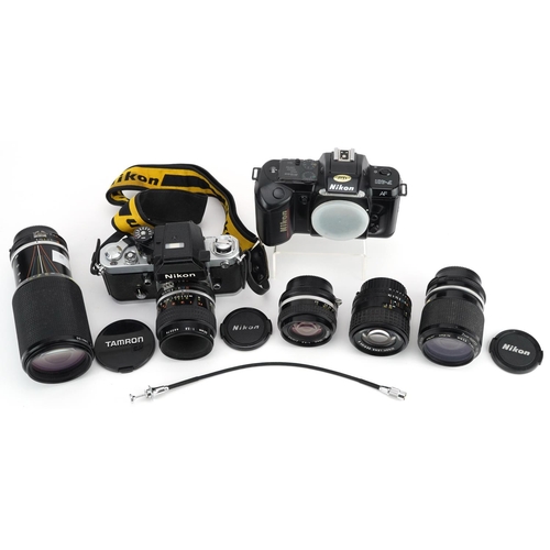 513 - Two Nikon cameras with a collection of lenses including 100mm 2.8, 20mm F-35 and 80-200mm.