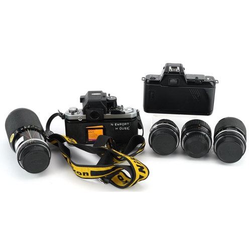 513 - Two Nikon cameras with a collection of lenses including 100mm 2.8, 20mm F-35 and 80-200mm.