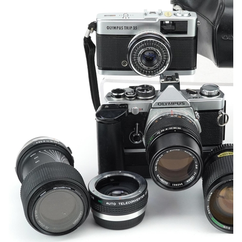 521 - A collection of cameras with lenses including Olympus OM-1, Olympus OM-2, 28-80mm and 70-210mm.