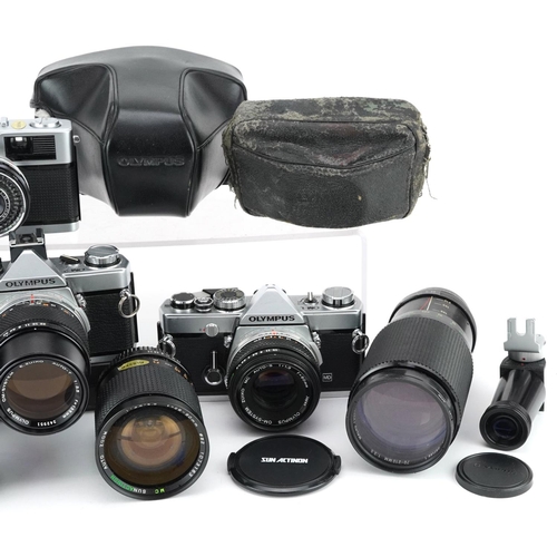 521 - A collection of cameras with lenses including Olympus OM-1, Olympus OM-2, 28-80mm and 70-210mm.