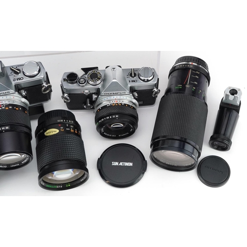 521 - A collection of cameras with lenses including Olympus OM-1, Olympus OM-2, 28-80mm and 70-210mm.