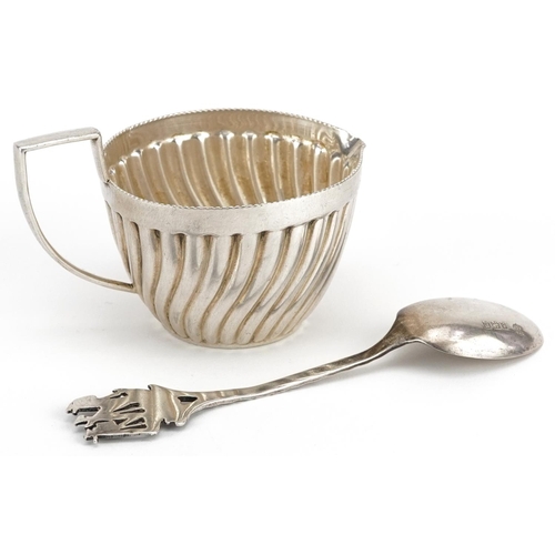 459 - A continental white metal embossed cream jug and a silver teaspoon with ship design terminal, the sp... 