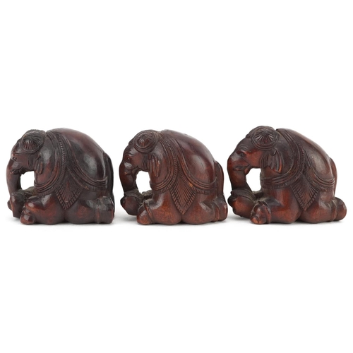 118 - Three Indian carved hardwood kneeling elephants, 20th century, 4cm high.