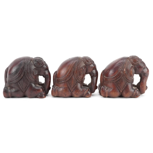 118 - Three Indian carved hardwood kneeling elephants, 20th century, 4cm high.