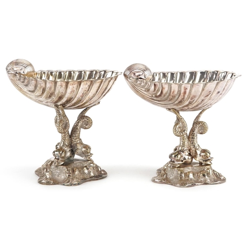 1358 - A pair of late 19th century plated bonbon dishes, the half shell bowl raised on three dolphin suppor... 