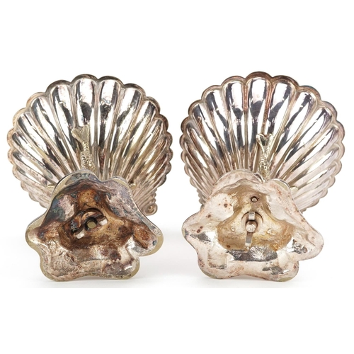 1358 - A pair of late 19th century plated bonbon dishes, the half shell bowl raised on three dolphin suppor... 