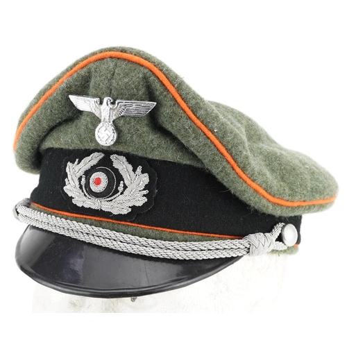 2594 - A German military interest visor cap with insignia.