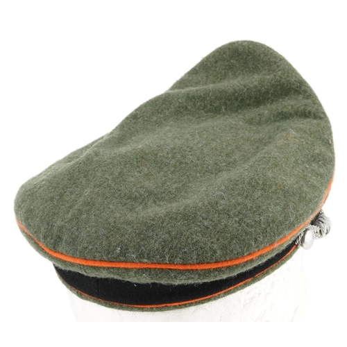 2594 - A German military interest visor cap with insignia.