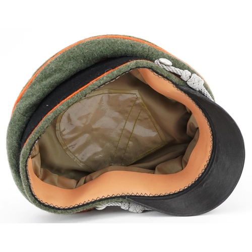 2594 - A German military interest visor cap with insignia.