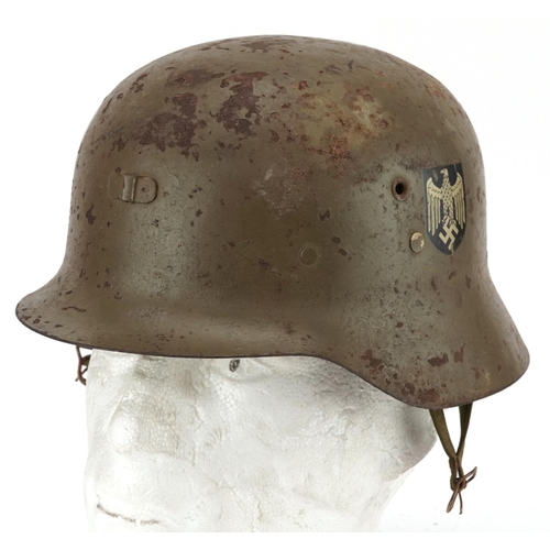 2595 - A Spanish military interest tin helmet with decals and liner.