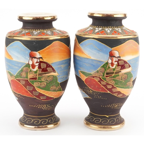 1368 - A pair of Japanese Satsuma pottery vases hand painted with figures. 26cm high