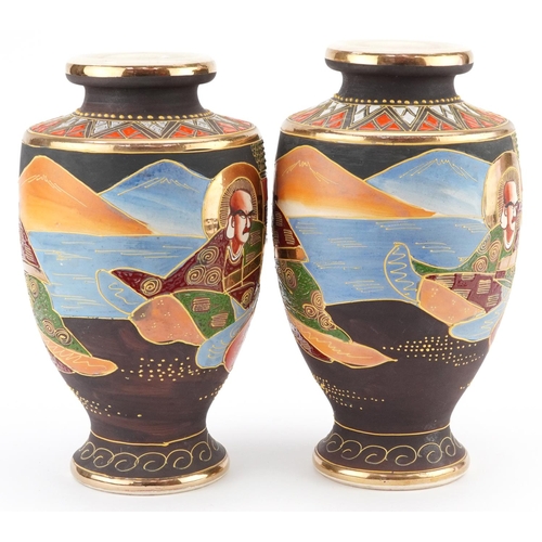 1368 - A pair of Japanese Satsuma pottery vases hand painted with figures. 26cm high